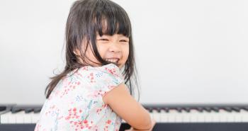 Child Smiling in front of a piano