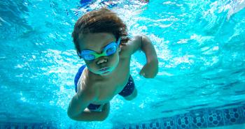 Child confidently swimming in a pool