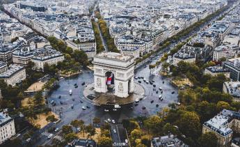 Photo of the arc in Paris with cars circling. 