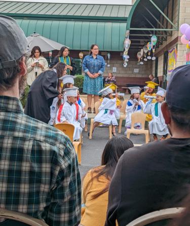 Child Looks Through Diploma like a looking glass at graduation