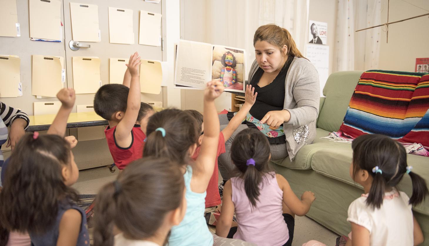Teacher with a group of children reading a story