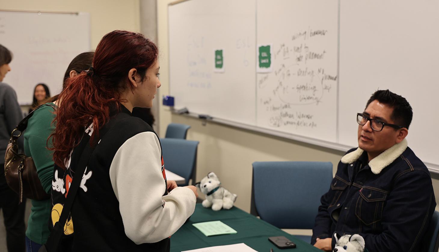 Student speaking with staff member.