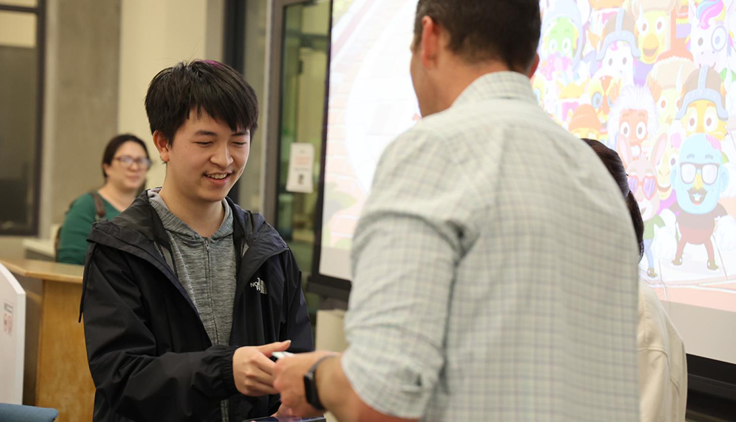 Faculty handing a student a prize.