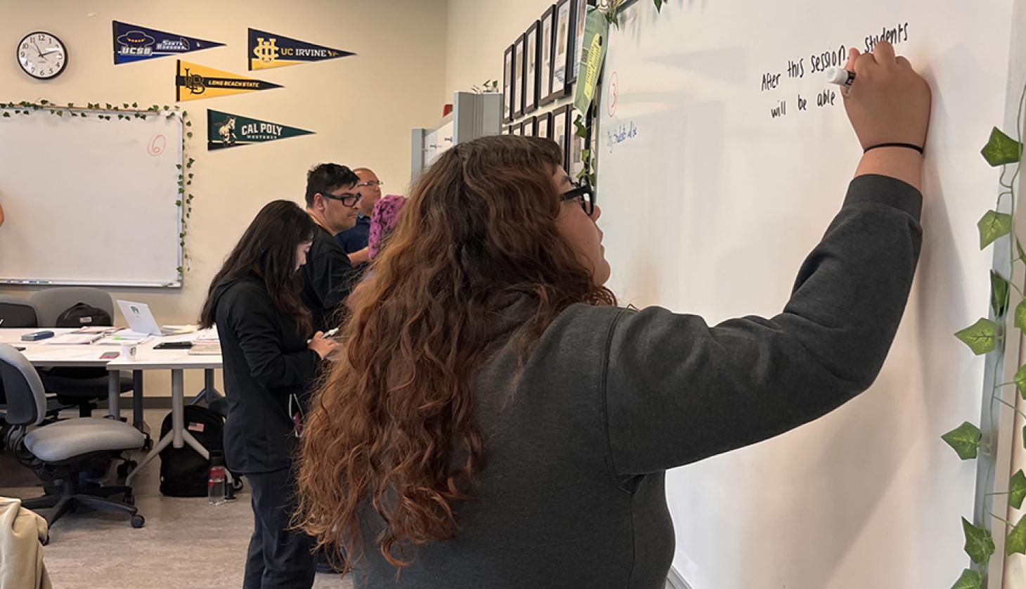 Student writing on whiteboard.